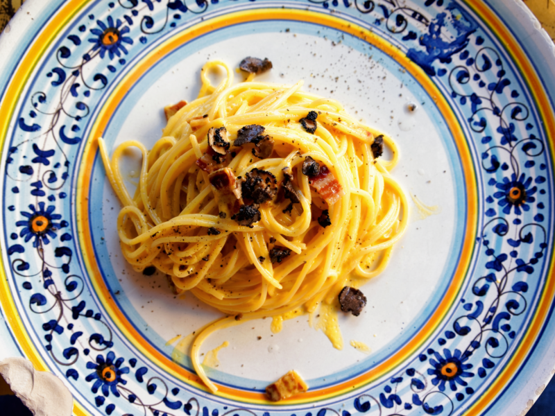 Italian traditional pasta alla carbonara with truffles mushrooms on plate in restaurant in Florence, Tuscany, Italy