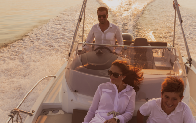 A senior couple in casual outfits with their son enjoy while riding a boat at sea at sunset. The concept of a happy family. Selective focus A senior couple in casual outfits with their son enjoy while riding a boat at sea at sunset. The concept of a happy family. Selective focus