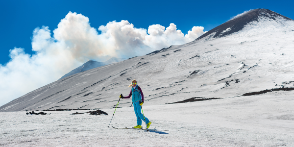 Girl ski touring under the top of the crater of Mount Etna Sicily Italy