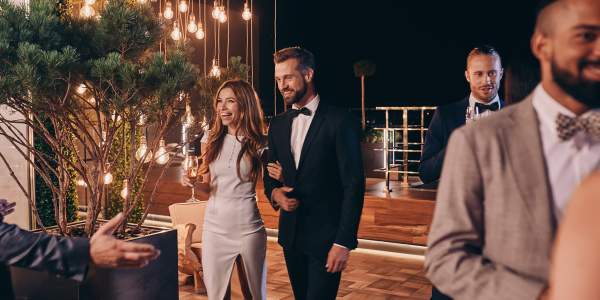 Group of people in formalwear communicating and smiling while spending time on luxury party