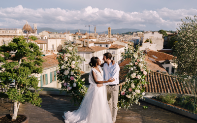 Multiethnic wedding couple. Destination fine-art wedding in Florence, Italy. A wedding ceremony on the roof of the building, with cityscape views of the city and the Cathedral of Santa Maria Del Fiore Prove o romance e exclusividade de um aniversário de casamento com vista para a Catedral em Florença.
