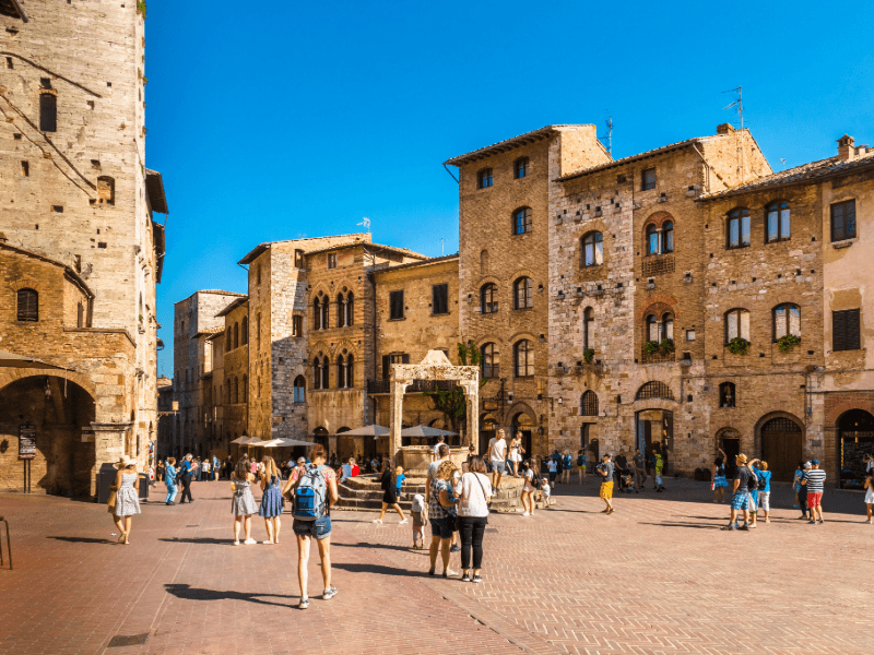 Viva a atmosfera única da Piazza della Cisterna, rodeada por torres!