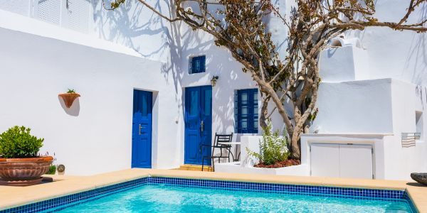 White cycladic architecture in Santorini island, Greece. Beautiful terrace with swimming pool and decorative tree